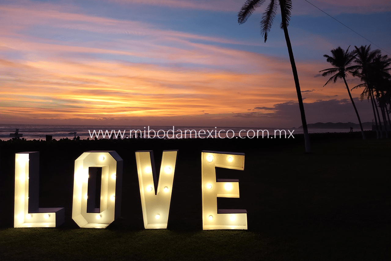 Letras decorativas "LOVE" iluminadas estilo vintage durante boda con DJ en Acapulco